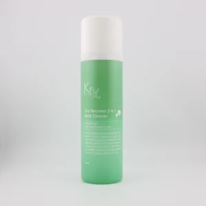 Das Bild zeigt eine zylindrische, grüne Flasche mit weißem Deckel von der Marke KRx Aesthetics. Auf der Flasche steht in weißer Schrift der Produktname: „Cica Recovery 2 in 1 Mask Cleanser“. Es handelt sich um ein Kombinationsprodukt aus Maske und Reinigungsschaum, das als sanfte und hydratisierende Reinigungslösung dient. Die Verpackung enthält 200 ml. Unterhalb des Namens steht: „A clay to foam – Mask and Cleanser in one“ sowie eine kurze Beschreibung, die auf die beruhigenden, regenerierenden Eigenschaften hinweist, besonders geeignet bei Ekzemen, Psoriasis, Allergien und trockener Haut.