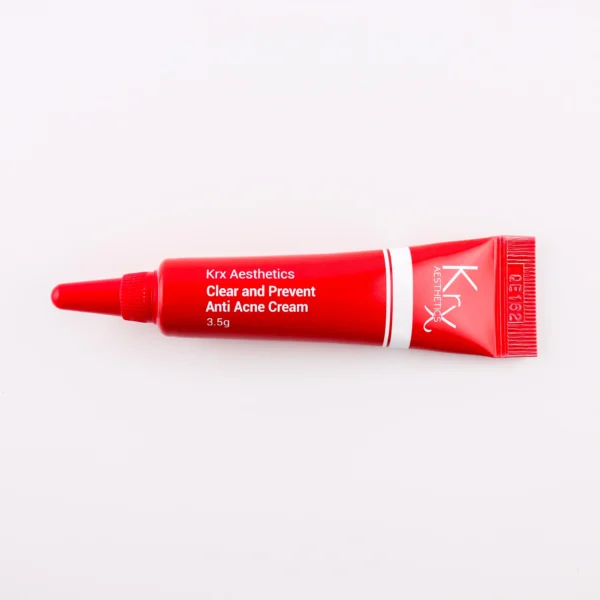 Das Bild zeigt eine tiefrote Tube mit einer spitzen Dosierspitze, die auf einem beigen Hintergrund liegt. Das Produkt gehört zur KRX Aesthetics-Reihe und heißt „Clear and Prevent Anti Acne Cream“. Die Tube ist rot mit weißem Schriftzug und einer dünnen weißen Linie. Die Füllmenge beträgt 3,5 g. Die Beleuchtung ist sanft und gleichmäßig.