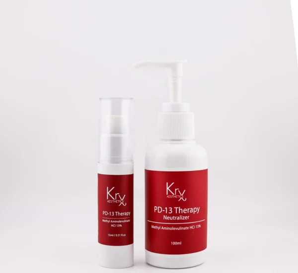 Das Bild zeigt zwei Produkte der Marke KrX Aesthetics mit dem Namen PD-13 Therapy. Links steht ein kleinerer Airless-Spender mit 15 ml Inhalt. Das Etikett ist in einem kräftigen Rotton gehalten und trägt die Aufschrift „PD-13 Therapy – Methyl Aminolevulinate HCl 13%“. Rechts daneben befindet sich ein größerer Pumpflakon mit 100 ml Inhalt. Auch dieses Produkt hat ein rotes Etikett mit der Beschriftung „PD-13 Therapy Neutralizer – Methyl Aminolevulinate HCl 13%“. Beide Verpackungen wirken professionell, modern und medizinisch-kosmetisch. Der Hintergrund ist hell und schlicht gehalten, wodurch der Fokus vollständig auf den Produkten liegt.