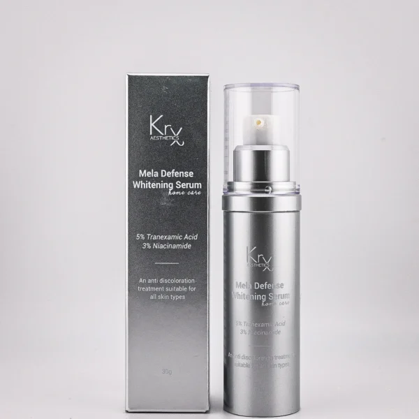 Ein aufhellendes Serum von KRX Aesthetics mit dem Namen "Mela Defense Whitening Serum". Die Flasche ist silberfarben und hat einen durchsichtigen Pumpverschluss. Die Verpackung ist in Schwarz und Silber gehalten, mit weißer Schrift. Enthält 5% Tranexamic Acid und 3% Niacinamide zur Hautaufhellung. Produktbeschreibung: "An anti-discoloration treatment suitable for all skin types." Inhalt: 30 g. Luxuriöse und elegante Präsentation auf sandfarbenem Hintergrund.