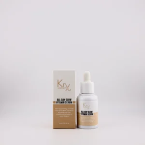 Das Bild zeigt ein Produkt der Marke Krx Aesthetics. Links im Bild steht ein cremefarbener Karton mit goldener Beschriftung. Daneben steht eine kleine weiße Flasche mit einem Pipettenverschluss, die optisch dem Karton entspricht. Es handelt sich um das “All Day Glow Vitamin Serum”, das in einer 30-ml-Größe (1.01 fl. oz.) angeboten wird. Die Pipettenflasche wirkt hochwertig und modern, mit klar strukturierter Schrift. Der Text auf der Verpackung beschreibt das Serum als ein leichtes, schnell einziehendes und nährendes Produkt, das die Haut aufhellt, glättet, klärt und intensiv mit Feuchtigkeit versorgt – für den sogenannten “All Day Glow”.