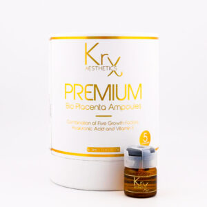 Das Bild zeigt ein hochwertiges Kosmetikprodukt der Marke KrX Aesthetics mit dem Namen PREMIUM Bio Placenta Ampoules. Die Verpackung ist rund, in elegantem Weiß mit goldenen Akzenten gehalten. Groß aufgedruckt ist der Markenname „KrX AESTHETICS“ sowie die Produktbezeichnung „PREMIUM Bio Placenta Ampoules“. Darunter steht: „Combination of Five Growth Factors, Hyaluronic Acid and Vitamin E“, was auf die Hauptwirkstoffe hinweist. Es handelt sich um eine intensive Ampullenkur mit regenerierenden und feuchtigkeitsspendenden Eigenschaften. Unten auf der Verpackung ist die Füllmenge mit „3 ml / 0.10 fl. oz.“ angegeben. Rechts daneben befindet sich eine kleine, bernsteinfarbene Ampulle mit einem hellen Verschluss – eine von insgesamt fünf enthaltenen Einheiten, wie die Markierung „5 ampoules“ anzeigt.