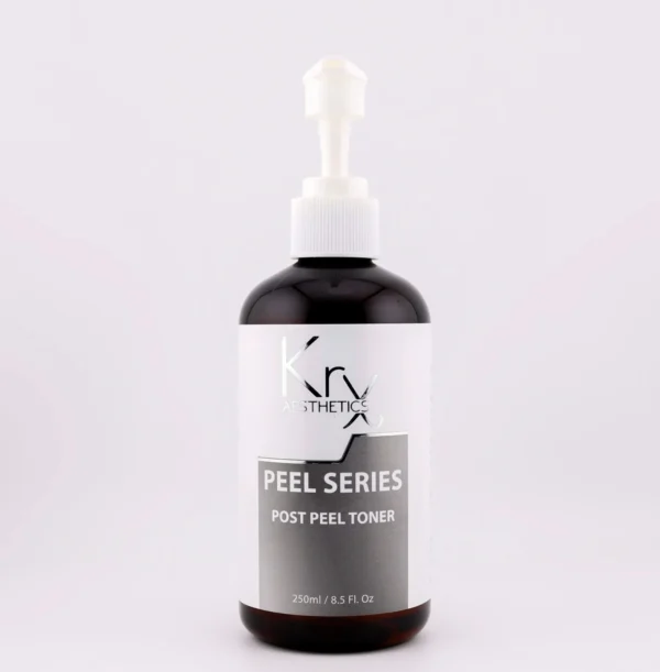 Das Bild zeigt eine schwarze Kunststoffflasche mit weiß-grauem Etikett und einem weißen Pumpspender. Auf dem Etikett steht „KrX AESTHETICS PEEL SERIES POST PEEL TONER“. Die Flasche enthält 250 ml (8.5 fl. oz) des Produkts. Der Toner ist Teil der professionellen Peeling-Serie von KrX und speziell für die Anwendung nach chemischen Peelings konzipiert. Das Produkt wirkt beruhigend, stellt den pH-Wert der Haut wieder her und unterstützt die Regeneration der Hautbarriere.