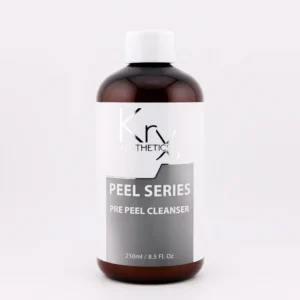 Das Bild zeigt eine braune Kunststoffflasche mit weißem Schraubverschluss. Auf dem Etikett steht in großer weißer Schrift: „Krx AESTHETICS – PEEL SERIES – PRE PEEL CLEANSER“. Die Flasche enthält 250 ml (8.5 fl. oz.) und gehört zur professionellen Produktlinie von KrX Aesthetics, die speziell für die Hautvorbereitung vor chemischen Peelings entwickelt wurde.