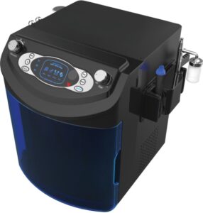 Das Bild zeigt ein kompaktes, modernes kosmetisches Behandlungsgerät namens OMEGA Hydro Cool. Das Gerät hat eine rechteckige Form mit abgerundeten Kanten. Der Hauptkörper ist schwarz, während die Frontpartie mit einer glänzenden, halbtransparenten blauen Abdeckung versehen ist. Oben auf dem Gerät befindet sich ein Bedienfeld mit einem digitalen Display in der Mitte, das blau beleuchtet ist. Links und rechts davon sind silberne Drehknöpfe und Bedientasten angebracht. Seitlich sind mehrere Handstücke befestigt, darunter eine Düse und weitere Applikatoren für kosmetische Anwendungen. Das Gerät wirkt robust, hochwertig verarbeitet und speziell für die professionelle Hautpflege entwickelt.
